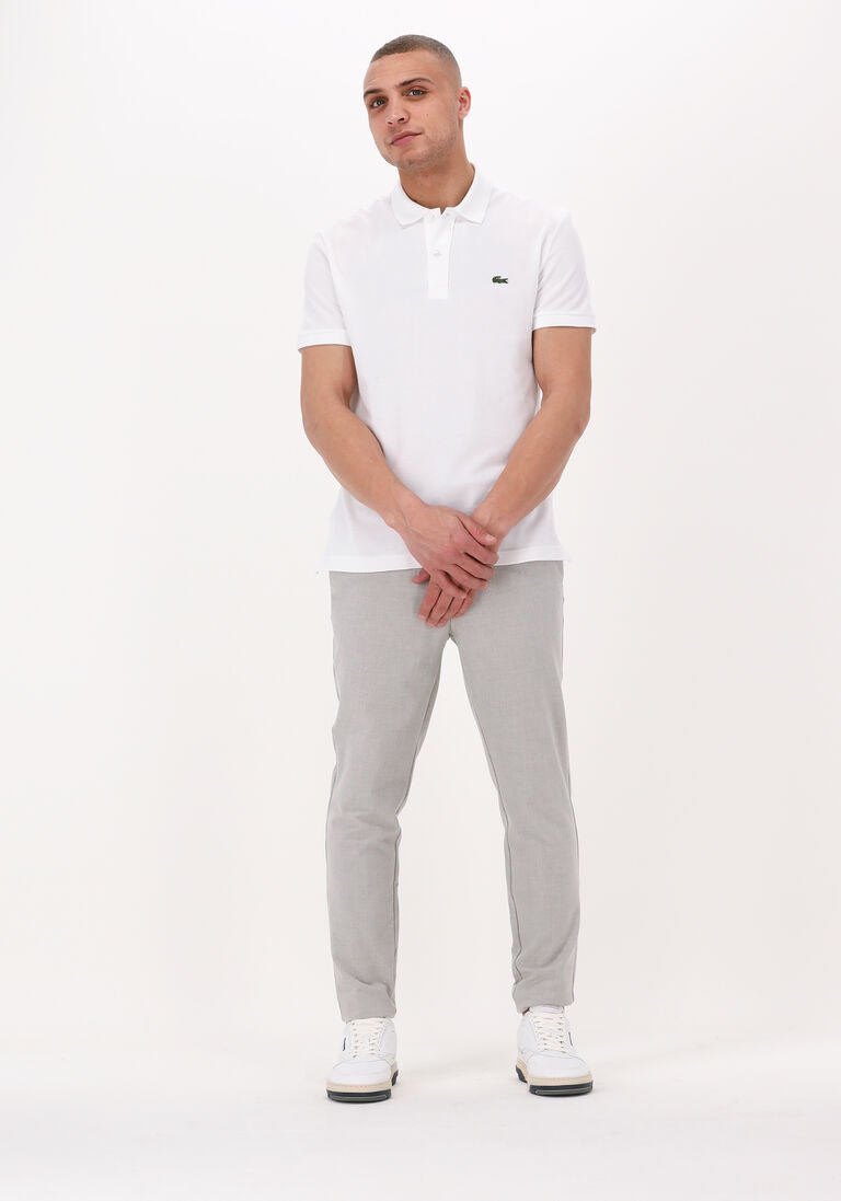 Femme en pull polo ajusté, tissu tricoté et col boutonné, look moderne inspiré de la marque Lacoste.