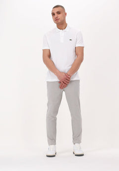 Femme en pull polo ajusté, tissu tricoté et col boutonné, look moderne inspiré de la marque Lacoste.