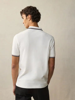 Tshirt polo blanc homme en tricot, vêtement léger et respirant, idéal pour un look sport chic et élégant.

